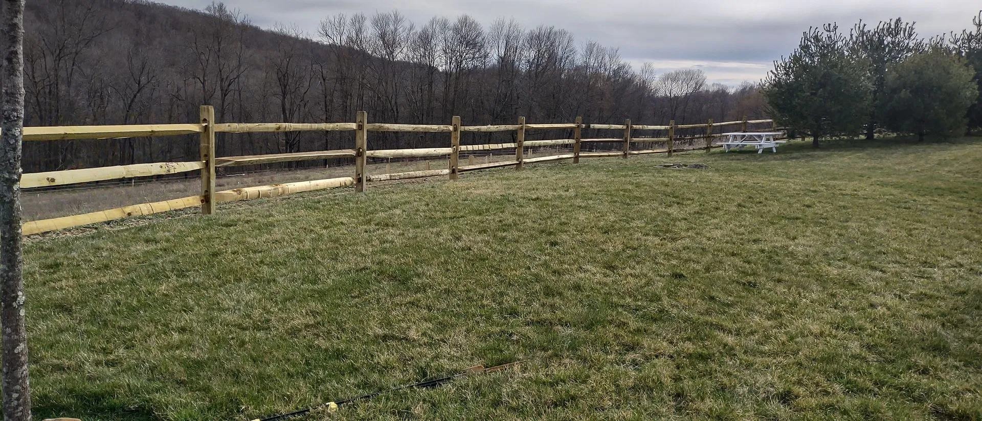 Split rail fence across an open field